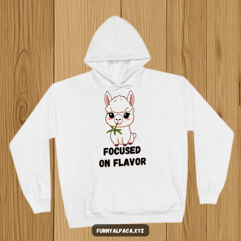 Funny alpaca hoodie depicting a determined alpaca character nibbling a green sprig, offering warmth and a touch of focused humor.